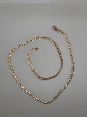 a gold necklace and bracelet set on a white surface