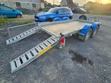 une remorque équipée d'une rampe, garée sur un parking