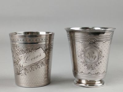 two silver cups with designs on them sitting next to each other