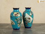 two vases sitting on a table with a wall in the background