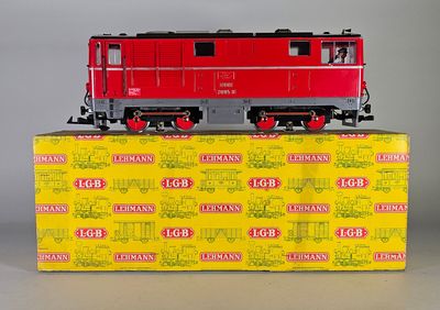 une locomotive rouge posée sur une boîte jaune
