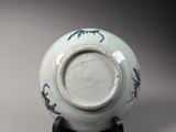 a blue and white vase on a stand on a gray background