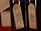 two bottles of wine with labels on them on a table