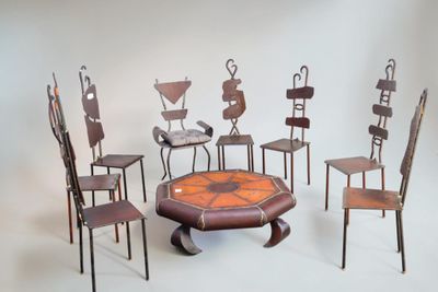 Plusieurs chaises et une table sont disposées en cercle sur un fond blanc.