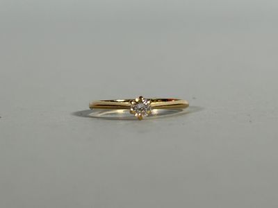 a close up of a diamond ring on a white surface