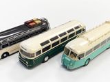 trois bus miniatures posés les uns à côté des autres sur une surface blanche