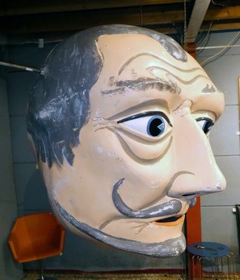 une grande tête d'homme qui se trouve dans une pièce