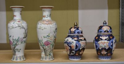 quatre vases exposés sur une étagère dans une vitrine