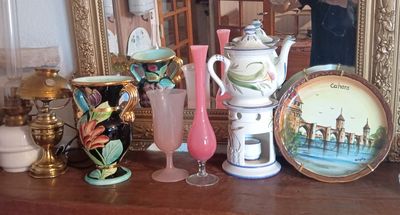 un homme en train de prendre une photo d'une collection de vases posés sur une table