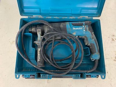 une boîte bleue contenant une perceuse et un cordon