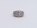 an image of a three stone diamond ring on a white surface