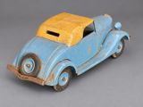 a blue toy car with a yellow top on a gray surface