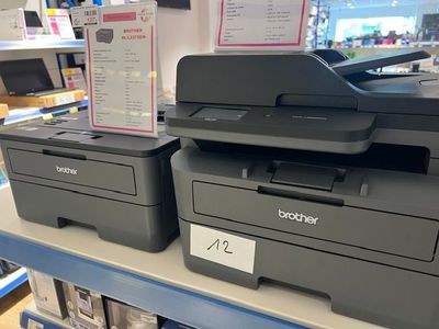 deux imprimantes posées sur une étagère dans un magasin