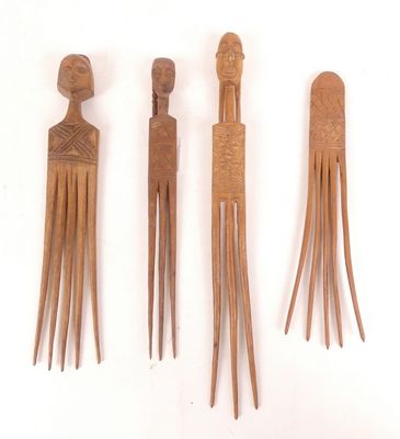 trois peignes en bois sont alignés sur une surface blanche