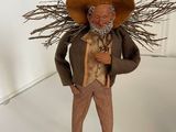 a figurine of a man wearing a hat and holding a stick