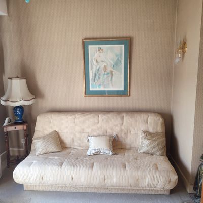 un canapé dans un salon avec un tableau accroché au mur