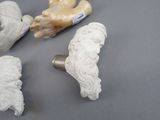 four ceramic figurines of a man and a woman on a gray surface