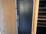 a refrigerator that is open in the corner of a room
