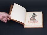 quelqu'un tient un livre ouvert sur lequel figure la photo d'un homme