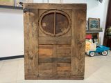 an old wooden door with a round window in the middle