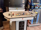 une petite console de jeux vidéo dans une pièce où se trouvent de nombreux autres jeux