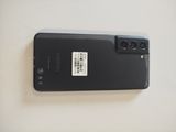 the back of a black cell phone with a white sticker on it