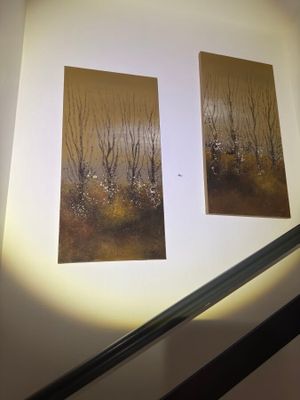 two paintings hanging on the wall above the stairs