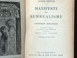 un vieux livre posé sur une étagère en bois, à côté d'un autre livre