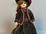 une poupée qui porte une robe et un chapeau