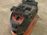an orange and black machine sitting on top of a cement floor