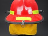 red fireman ' s hat with yellow tape on it