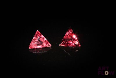 une paire de boucles d'oreilles en diamants roses sur fond noir