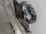 a silver plate with a mirror on it on a wall