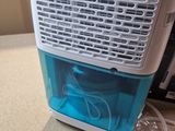 a small air conditioner sitting on a counter next to a microwave