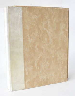 an old book sitting on top of a white table next to a white wall