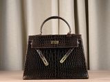 the brown crocodile skin handbag is sitting on a wooden table