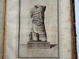 an old book with a drawing of a statue on it