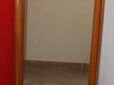 a mirror sitting next to a red wall in a room