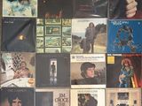 many different album covers on the wall of a room