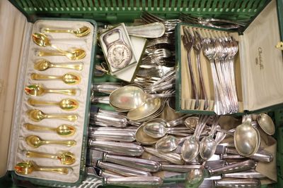 une boîte verte remplie d'argenterie et de cuillères en argent