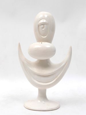 a white vase with a face on top of it