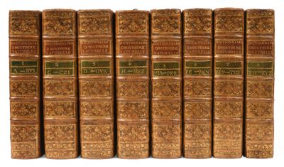 six vieux livres sont alignés sur une surface blanche