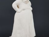 a white statue of a woman sitting on top of a white base