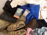 a pile of clothes and a pair of shoes on the floor