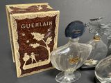three glass bottles and a box of perfumes on a table
