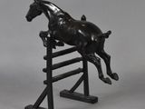 a statue of a horse jumping over an obstacle