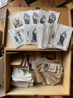 une boîte remplie de vieilles photos et de cartes, posée par terre
