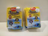 two packs of huggies swim diapers sitting on top of a counter