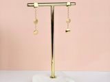 a gold plated earring stand with a pair of earrings hanging from it