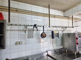 une cuisine équipée d'une cuisinière, d'un évier et d'autres éléments fixés au mur